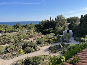 Jardim bem cuidado com zona de churrasco e vista para o mar