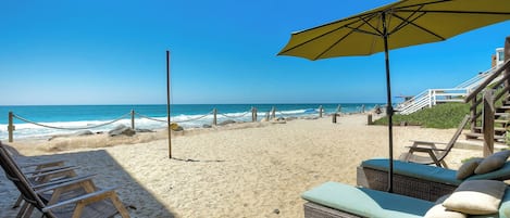 Private beach with lounge seats, chairs, and teatherball