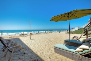 Private beach with lounge seats, chairs, and teatherball