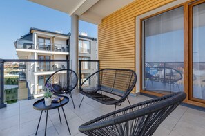 Spacious balcony with outdoor furniture. 