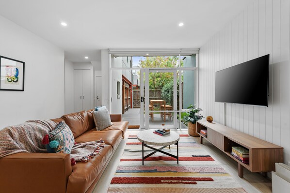 A living room with a couch, table, and television 