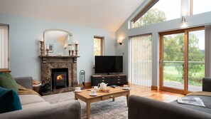 Coorie Lodge  living room with woodburner and TV