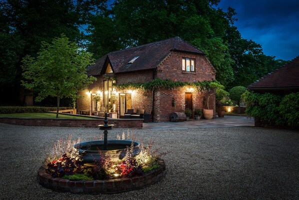 Exterior driveway and lit up cottage 