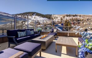 Rio Grande's rooftop sitting area with fire table overlooking snow covered mountains.