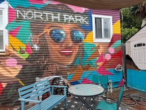 Outdoor bliss awaits! Sip, chat, and soak in the beauty of a mural-adorned patio. 4 seats, 1 table - your perfect spot for coffee, talks, and laughter.