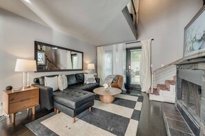 French doors open to the outdoor patio, living room with a roomy leather sectional and plenty of seating, plus a large Smart TV for ultimate relaxation and entertainment.