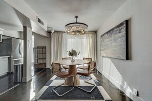Open dining area with seating for four, featuring a beautiful chandelier..