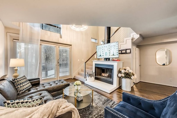 Spacious and bright living room with wood burning fireplace.