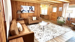 LIving room with plenty of sitting and a smart TV.