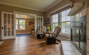 Comfortable conversation area with french doors leading to large entryway