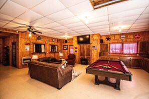 Large living area w/pool table, TV and ceiling fans.