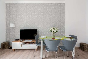 Another angle of the same living room showing the dining area and a decorative vase on the table.