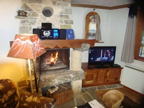 Le salon avec la cheminée et la télévision