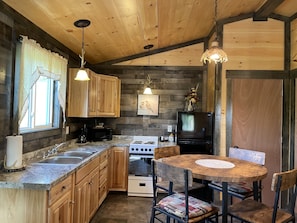 Kitchen complete with sink, stove, refrigerator, microwave, coffee pot.