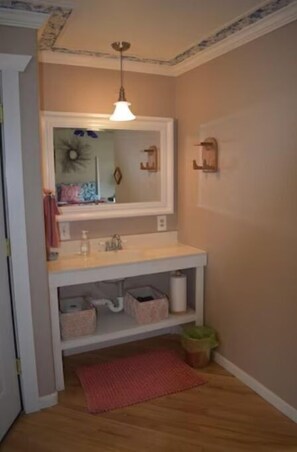 Vanity with one sink located in a nook in the bedroom.