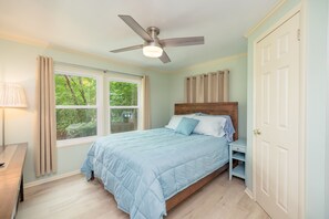 Comfortable br#1 w/ a queen bed, ceiling fan, closet, dresser, and a 43" TV. 
