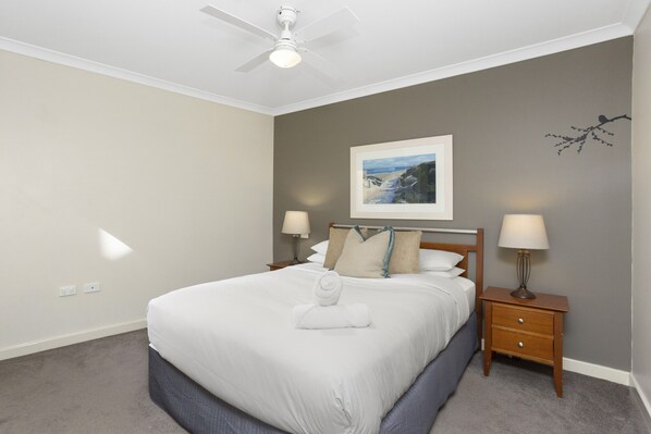 Unwind in this cozy bedroom, featuring a comfortable bed and soft linens.