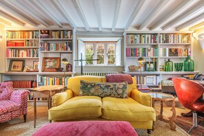 Ford Cottage, Corscombe: Comfortable seating and well-stocked bookshelves for relaxing  in the sitting room