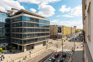 A lively cityscape with modern architecture and street activity, showcasing the apartment's central location.
