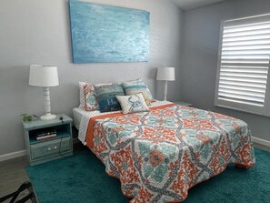 Large master bedroom with natural light and double nightstands. 