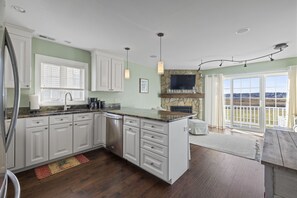 Fully stocked kitchen opens into a sitting area with pull out couch & chairs