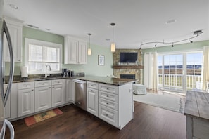 Fully stocked kitchen opens into a sitting area with pull out couch & chairs