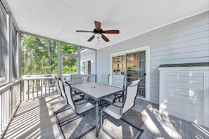 The screen porch has a large table for dining outside