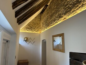 A historic welcome featuring oak beams and original stone walls. 