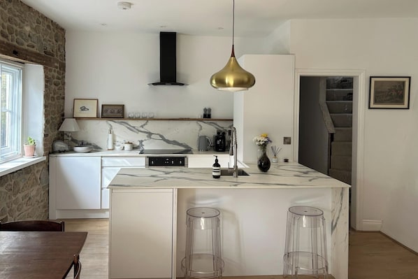 A stylish modern kitchen with breakfast bar, oven, hob and dishwasher.