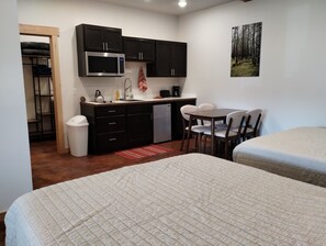 Leisure Suite - Equipped with Two Queen Beds, Kitchenette, 32-inch Smart TV, and, Dining Area.