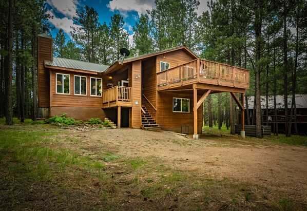 View of the front of the house and the porch off of the primary bedroom. 