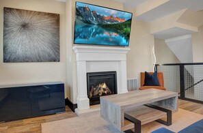 Living room with Smart TV and colorful velvet couch with leather chair