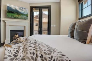 Main Suite with King Bed, gas burning fireplace, TV and private balcony.