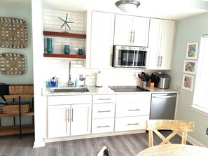 Coastal vibe kitchenette with crushed ice maker and mini stainless fridge.