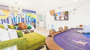 Relaxing lounge, merging entertainment with comfort: poker table, plush couch, and TV.