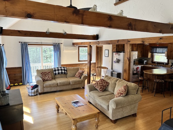 View of living area, kitchen with eat-in island and door to side deck and yard