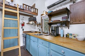 Kitchen with a stove, oven, coffee maker, and counter space