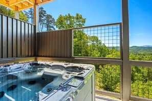Unwind in the outdoor hot tub while soaking in the serene mountain backdrop.