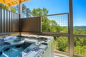 Unwind in the outdoor hot tub while soaking in the serene mountain backdrop.