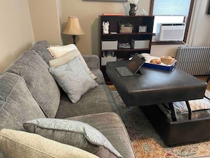 Enjoy cozy movie nights with loved ones on a comfortable sectional sofa that doubles as a queen-sized bed in this inviting living room. Work remotely in a comfortable workspace, or recharge your mind with a pretty view.