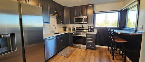 Kitchen with bar top seating for 2 with a view of the harbor