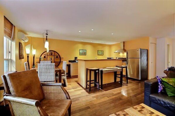 Living room and dining area with bar, tropical hardwood floors throughout