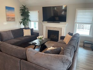 Living Room Sofa Pit with gas fireplace and 75" TV.