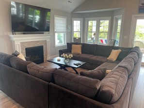 Living Room sofa pit with gas fireplace and 75" TV.