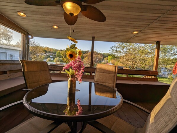 Table and chairs on spacious covered back porch w/ fenced in back yard