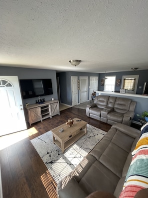 LIVING ROOM AREA WITH RECLINING LEATHER SOFAS; ALSO COFFEE TABLE.