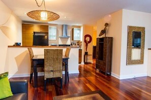 Dining area view towards kitchen & hallway. Tropical hardwood floors throughout.