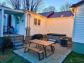 Backyard space with a 5 seater hot tub, black stone griddle and picnic table