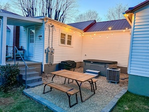 Backyard space with a 5 seater hot tub, black stone griddle and picnic table