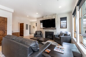 Living area offering a smart TV, cozy furnishings and a gas fireplace.